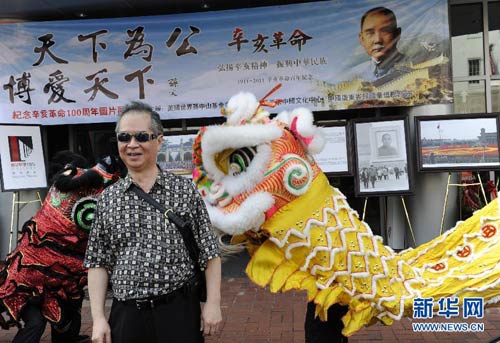 9月4日，在美国首都华盛顿唐人街，一名参观者在“纪念辛亥革命一百周年图片展”前留影。华盛顿唐人街当日人头涌动，来自哥伦比亚特区、马里兰州、弗吉尼亚州等附近地区华人欢聚一堂，共庆辛亥革命一百周年，观看“纪念辛亥革命一百周年图片展”。新华社记者 张军 摄