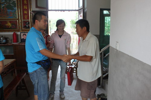 本文作者（左一）与中华慈善总会的工作人员慰问村里的困难户