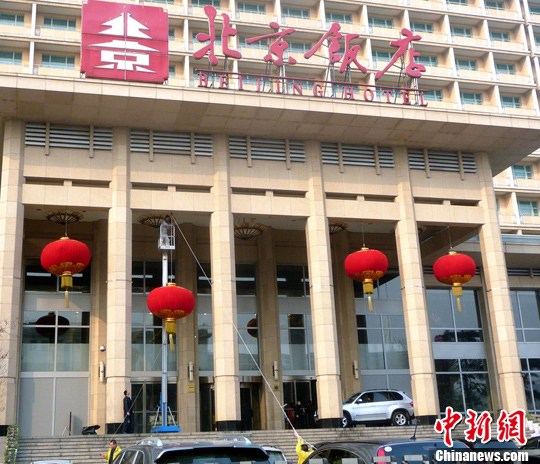 2012年2月27日，北京饭店主楼门前，工作人员正在悬挂大红灯笼、营造喜庆气氛，迎接全国“两会”的召开。