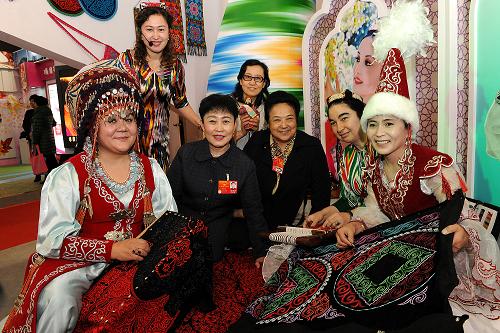3月9日，来自山东的全国人大代表陈桂云（左三）等与新疆展区的工作人员合影留念。新华社记者 何俊昌 摄