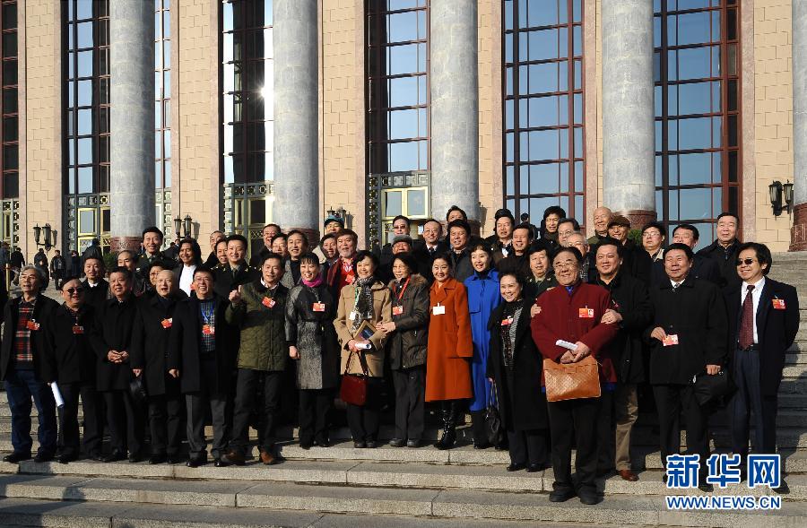 3月13日，中国人民政治协商会议第十一届全国委员会第五次会议在北京人民大会堂闭幕。这是一些委员在人民大会堂前合影。 新华社记者 燕雁摄