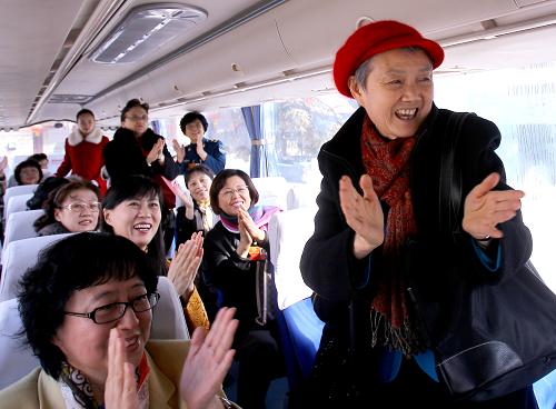 3月13日，中国人民政治协商会议第十一届全国委员会第五次会议在北京人民大会堂闭幕。入住铁道大厦的委员们乘车到达驻地后向司机和引导员鼓掌致谢。新华社记者 陈建力 摄