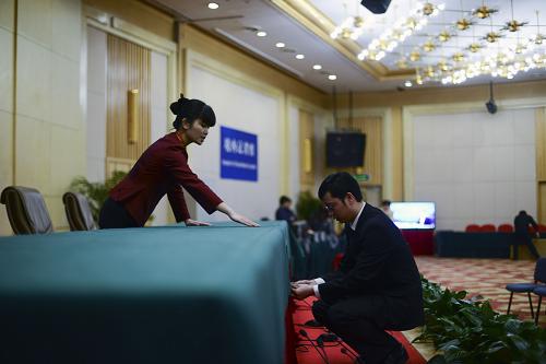 2月26日，工作人员在新闻发布厅铺台布。当日，设在北京梅地亚中心的2013年全国两会新闻中心正式启用，中心工作人员开始接待和安排中外记者采访。新华社记者 金良快 摄