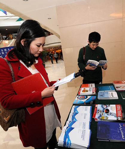 2月26日，两名记者在新闻中心翻阅资料。新华社记者 何俊昌 摄