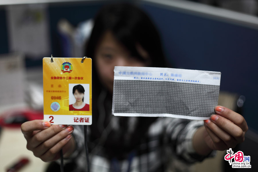 2013年2月28日，北京，参与全国政协十二届一次会议报道的内地记者展示记者证和密码函件。中国网 陈维松 摄