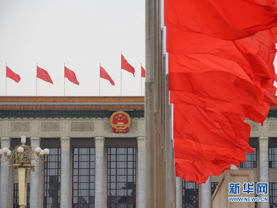 3月2日，人民大会堂上方布置的红旗迎风飘扬，喜迎2013年全国两会的召开。新华网 翟子赫摄