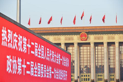 3月3日，北京人民大会堂前的大屏幕上显示出庆祝两会召开的标语。当日下午，全国政协十二届一次会议将在北京人民大会堂开幕。新华社发（王全超 摄）