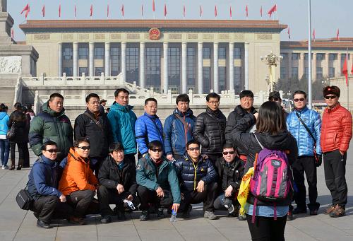 3月3日，一支韩国旅游团在人民大会堂前拍照留念。全国政协十二届一次会议将与3月3日下午在北京人民大会堂开幕。当日，天安门广场上阳光明媚，红旗招展，游人如织。新华社记者 王颂 摄