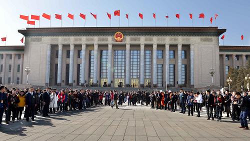 3月3日，中国人民政治协商会议第十二届全国委员会第一次会议即将在北京人民大会堂开幕。这是记者在人民大会堂外迎候即将到达广场的委员。新华社记者 王颂 摄