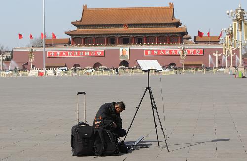 3月3日，中国人民政治协商会议第十二届全国委员会第一次会议在北京人民大会堂开幕。这是一名记者在天安门广场上准备采访工作。新华社记者邢广利摄