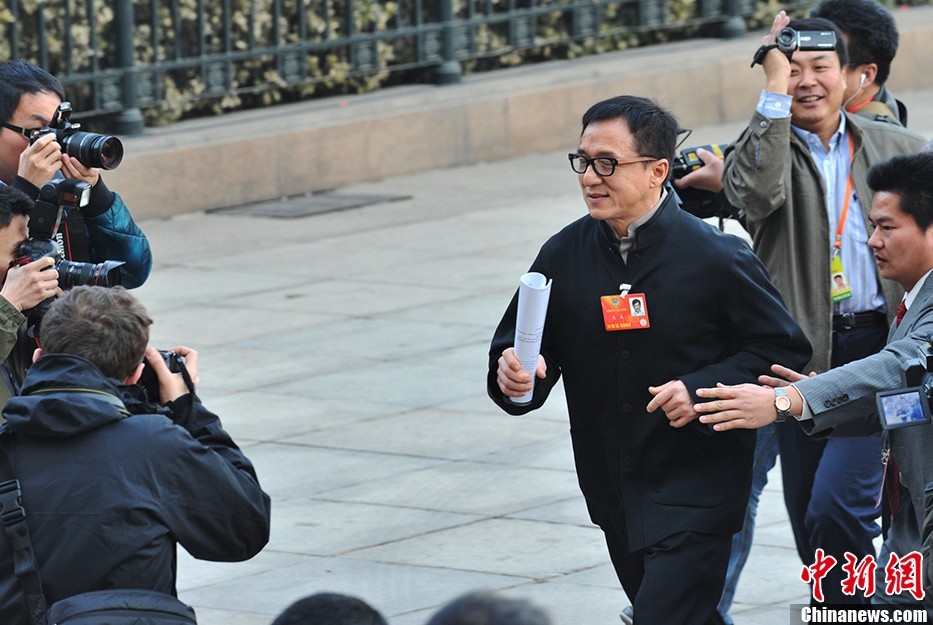 3月3日，全国政协十二届一次会议在北京人民大会堂隆重开幕。全国政协委员成龙在人民大会堂前跑步突围。中新社发 贾国荣 摄