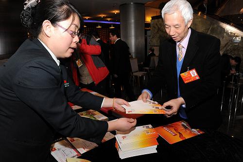  3月4日，来自香港的全国政协委员石汉基在购买两会纪念封。为迎接2013年两会，中国集邮总公司特别发行十二届全国人大一次会议和全国政协十二届一次会议纪念封等邮品，深受集邮爱好者青睐。新华社记者 何俊昌 摄